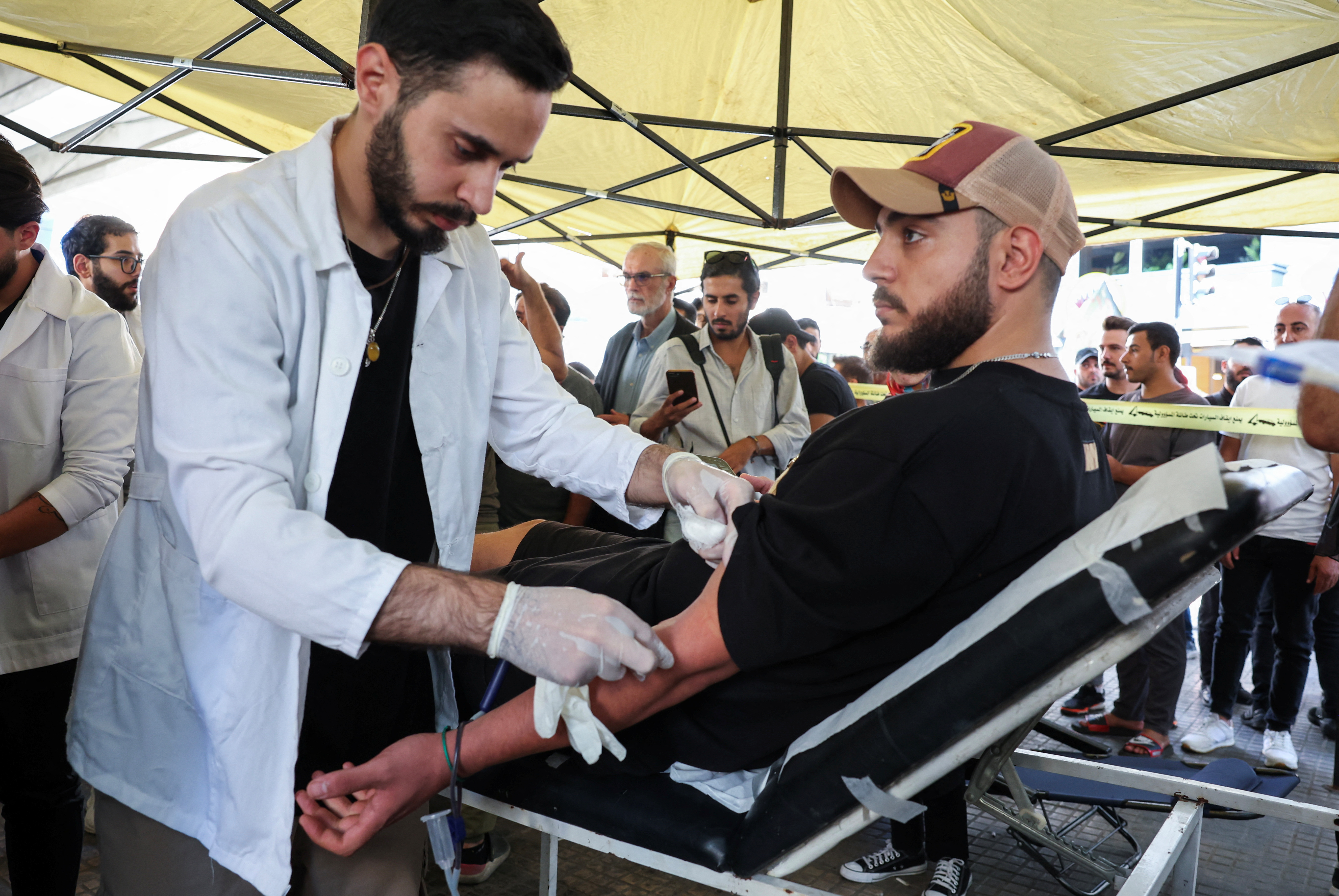 A man donates blood, following pager detonations across Lebanon on Tuesday, in Beirut suburbs