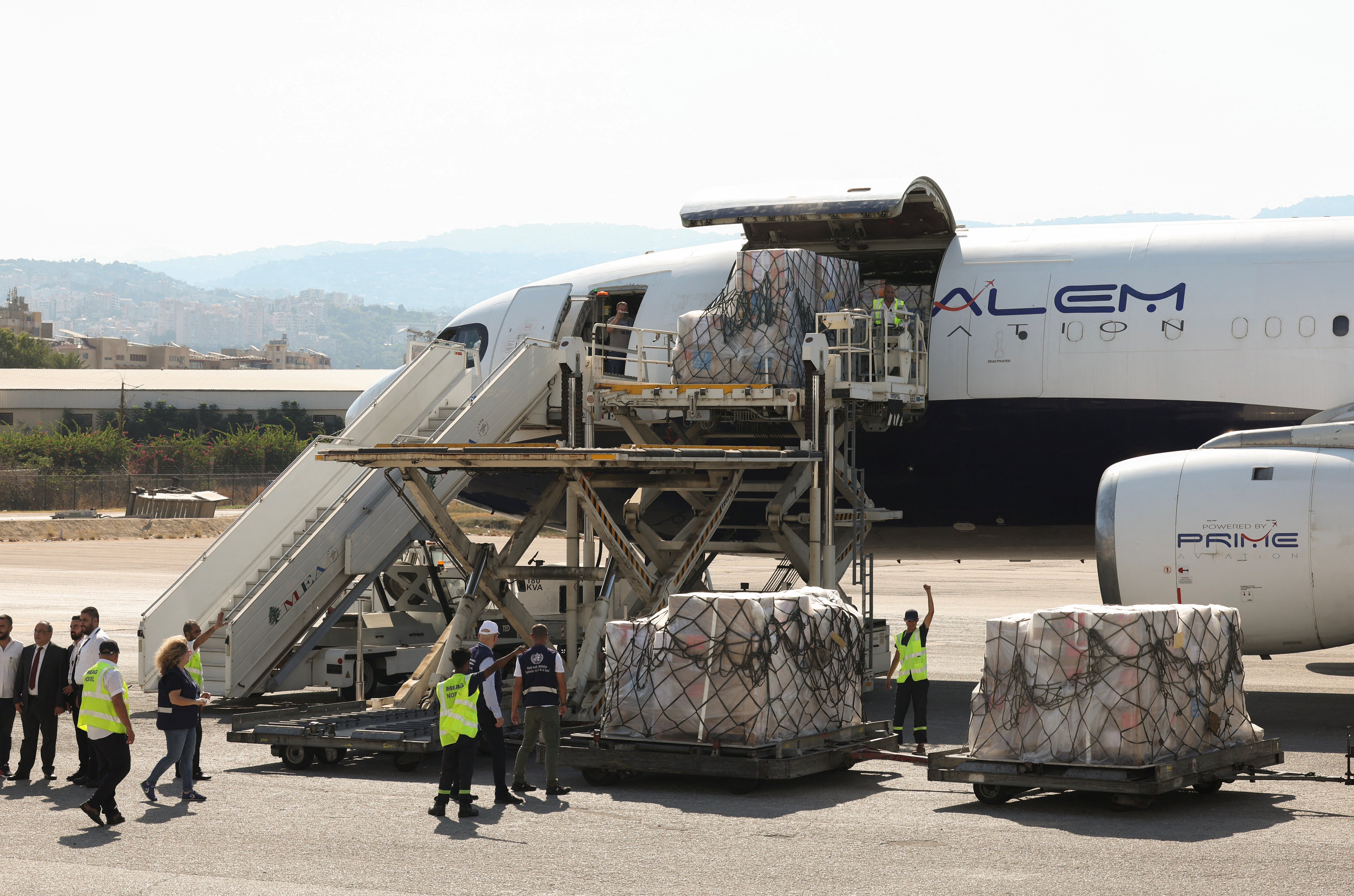 Workers unload medical supplies delivered by the World Health Organization for any potential health crisis resulting from hostilities, in Beirut