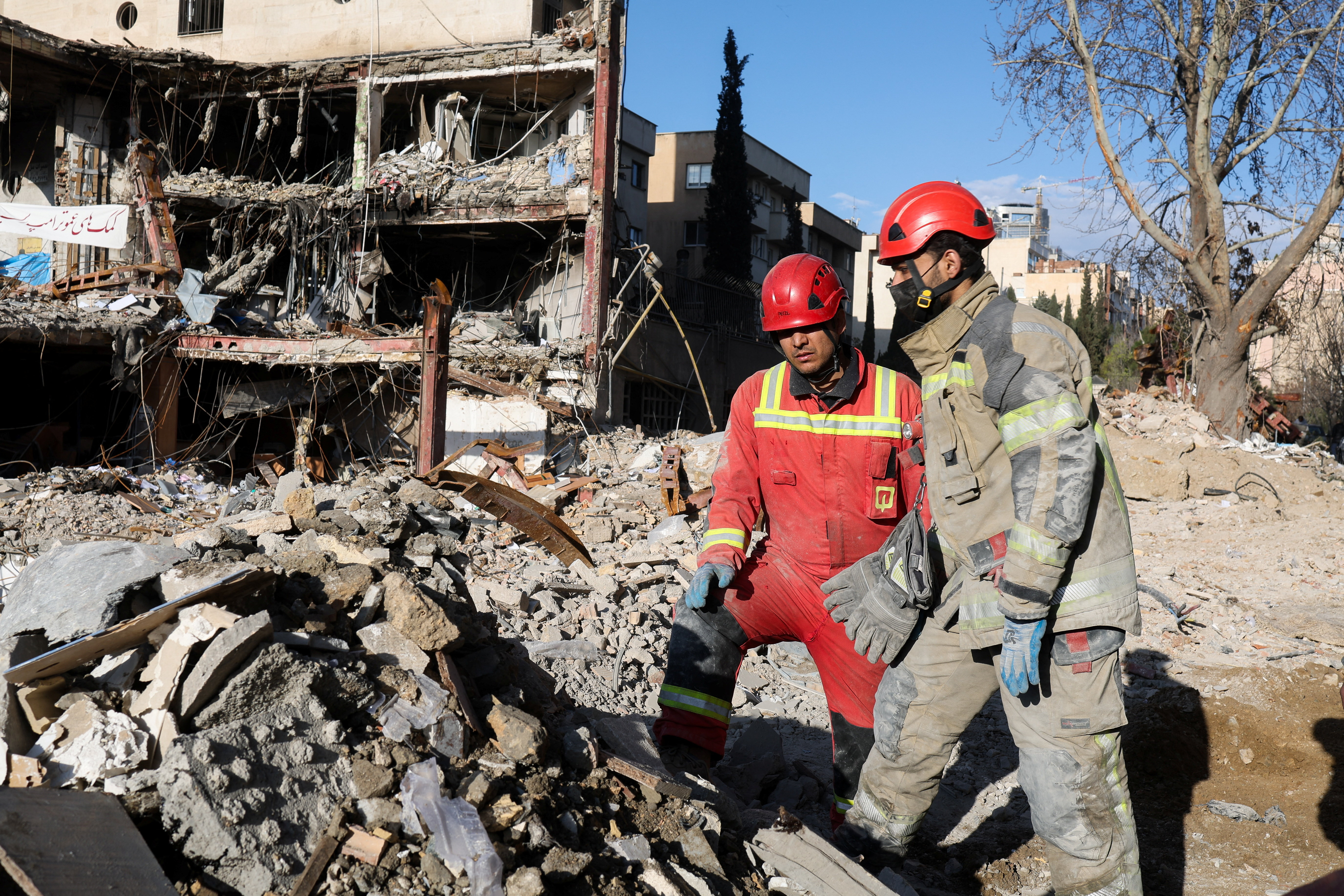 Members of a Red Crescent rescue team work at a building that was damaged by a strike, in Tehran