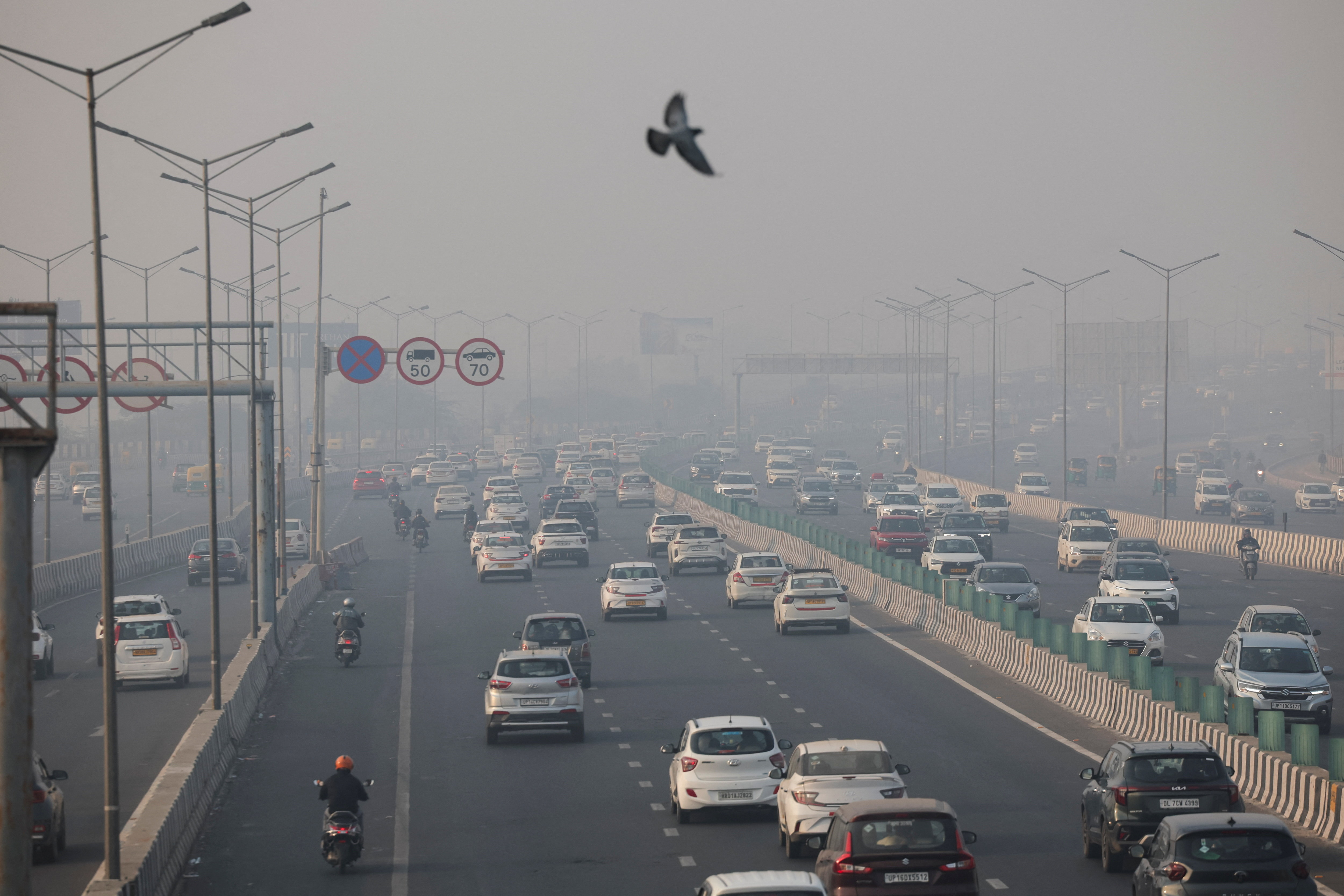 Vehicles ply on a highway, on a smoggy morning amid ongoing air pollution, in New Delhi
