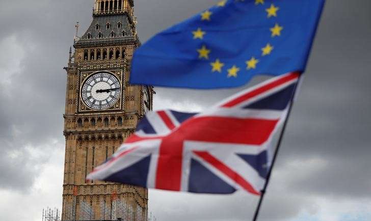FILE PHOTO: The Union Flag and a European Union flag fly near the Elizabeth Tower, housing the Big Ben bell, during the anti-Brexit 'People's March for Europe', in Parliament Square in central London