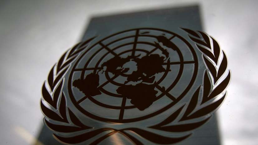 FILE PHOTO: The United Nations headquarters building is pictured though a window with the UN logo in the foreground in the Manhattan borough of New York
