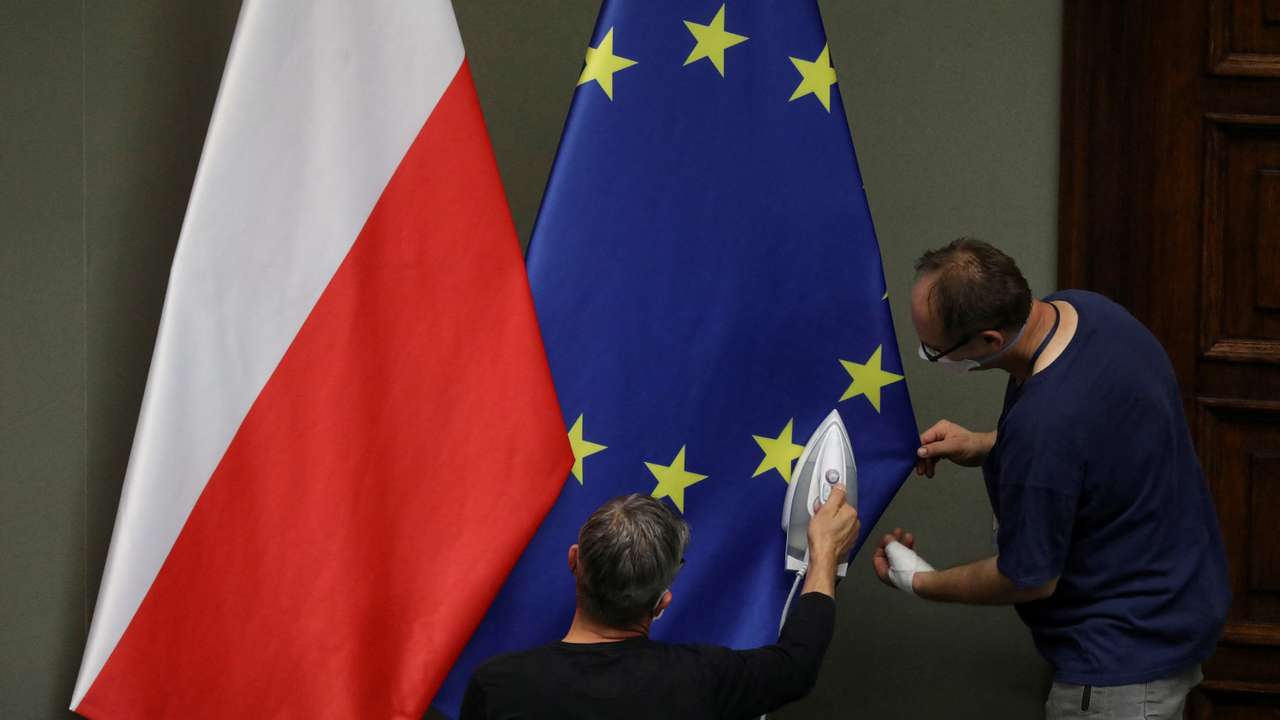 FILE PHOTO: Workers iron flags of European Union and Poland before the swearing-in ceremony of Andrzej Duda as Polish President in Warsaw