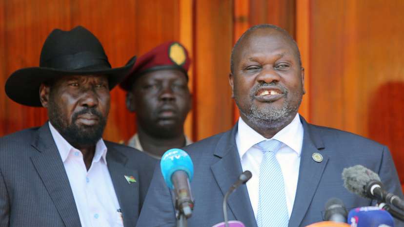 South Sudan's ex-vice President and former rebel leader Riek Machar flanked by President Salva Kiir Mayardit address a news conference at the State House in Juba