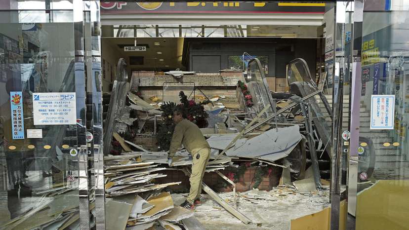 A worker cleans up inside a commercial facility in Hachinohe following a strong earthquake the previous night