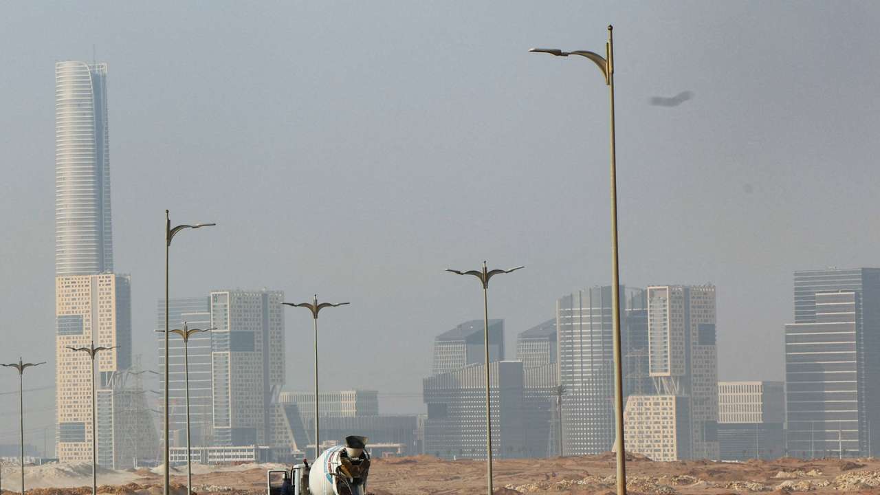 An Egyptian worker drives a construction tractor on the road at the New Administrative Capital (NAC) in the desert east of Cairo