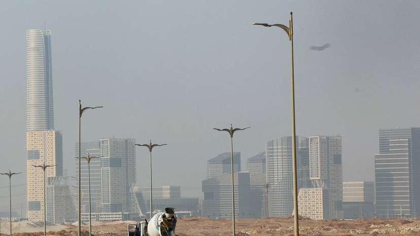 An Egyptian worker drives a construction tractor on the road at the New Administrative Capital (NAC) in the desert east of Cairo