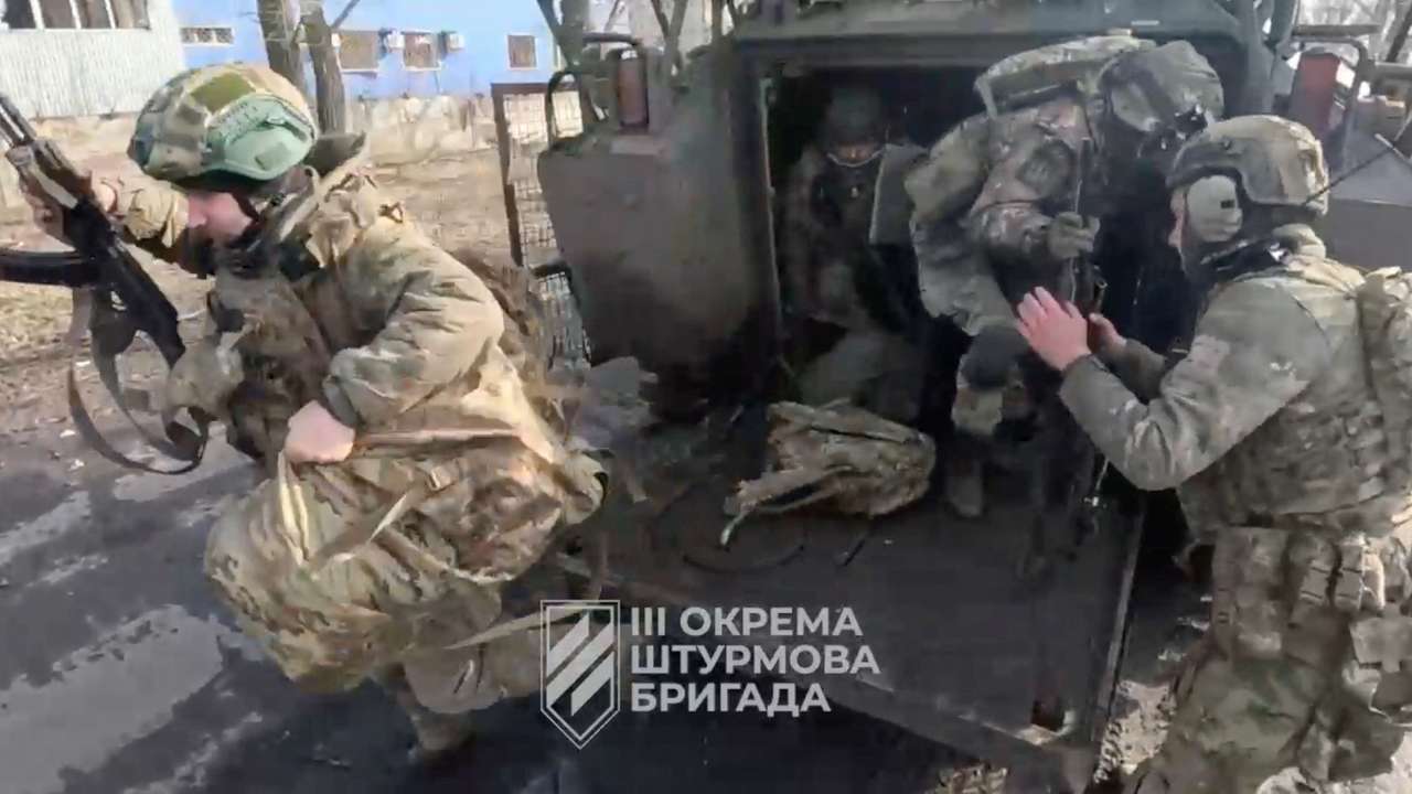 Ukrainian soldiers get out of a military vehicle in a location given as Avdiivka, Donetsk Region