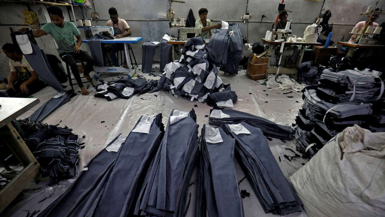 FILE PHOTO: Workers sew jeans in a garments manufacturing unit in Ahmedabad