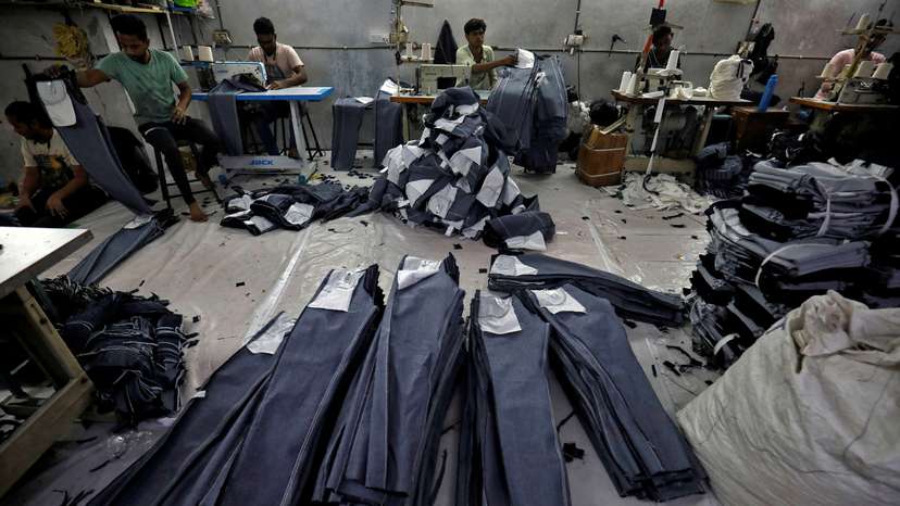 FILE PHOTO: Workers sew jeans in a garments manufacturing unit in Ahmedabad