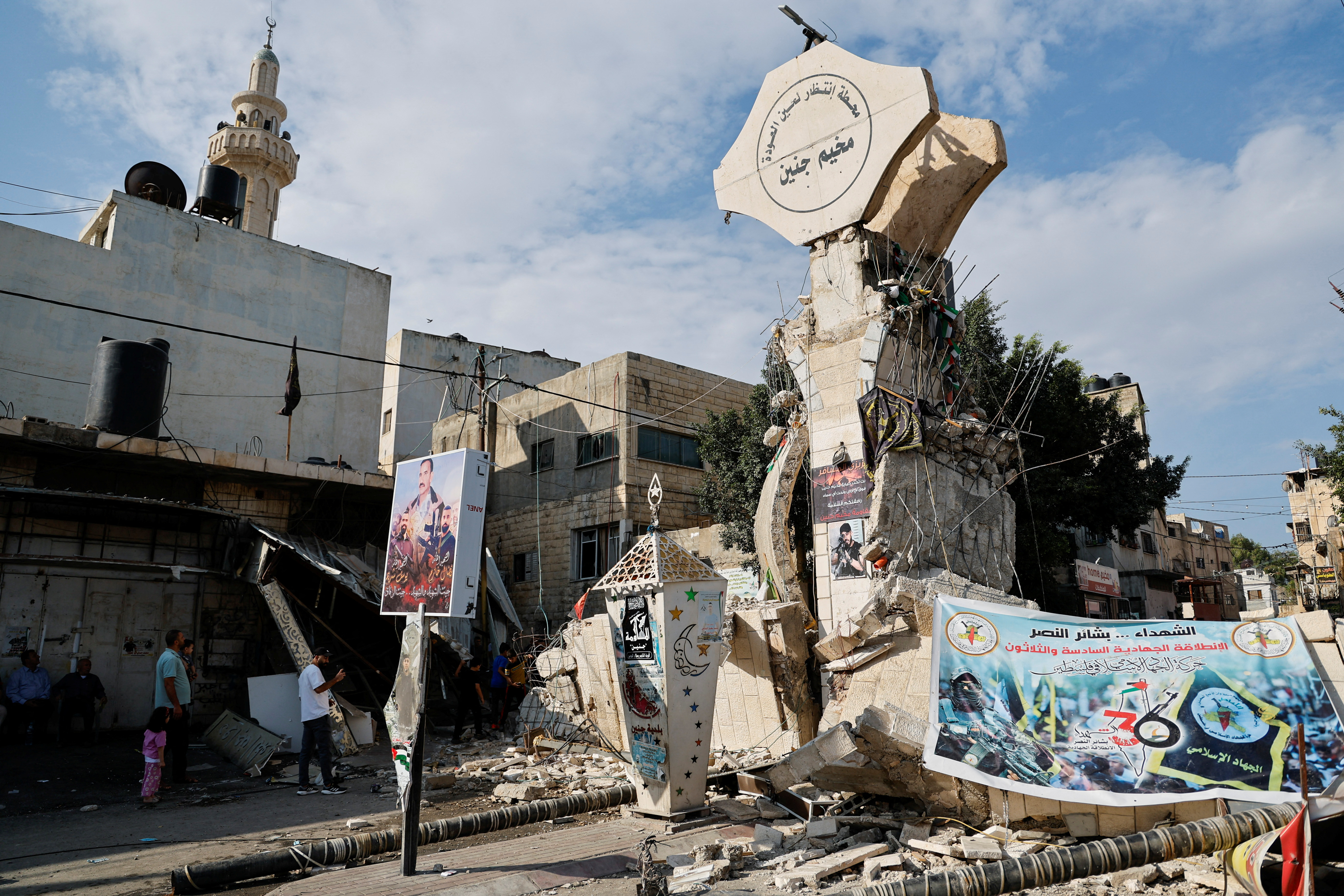 Palestinians check damaged streets following an Israeli raid in Jenin