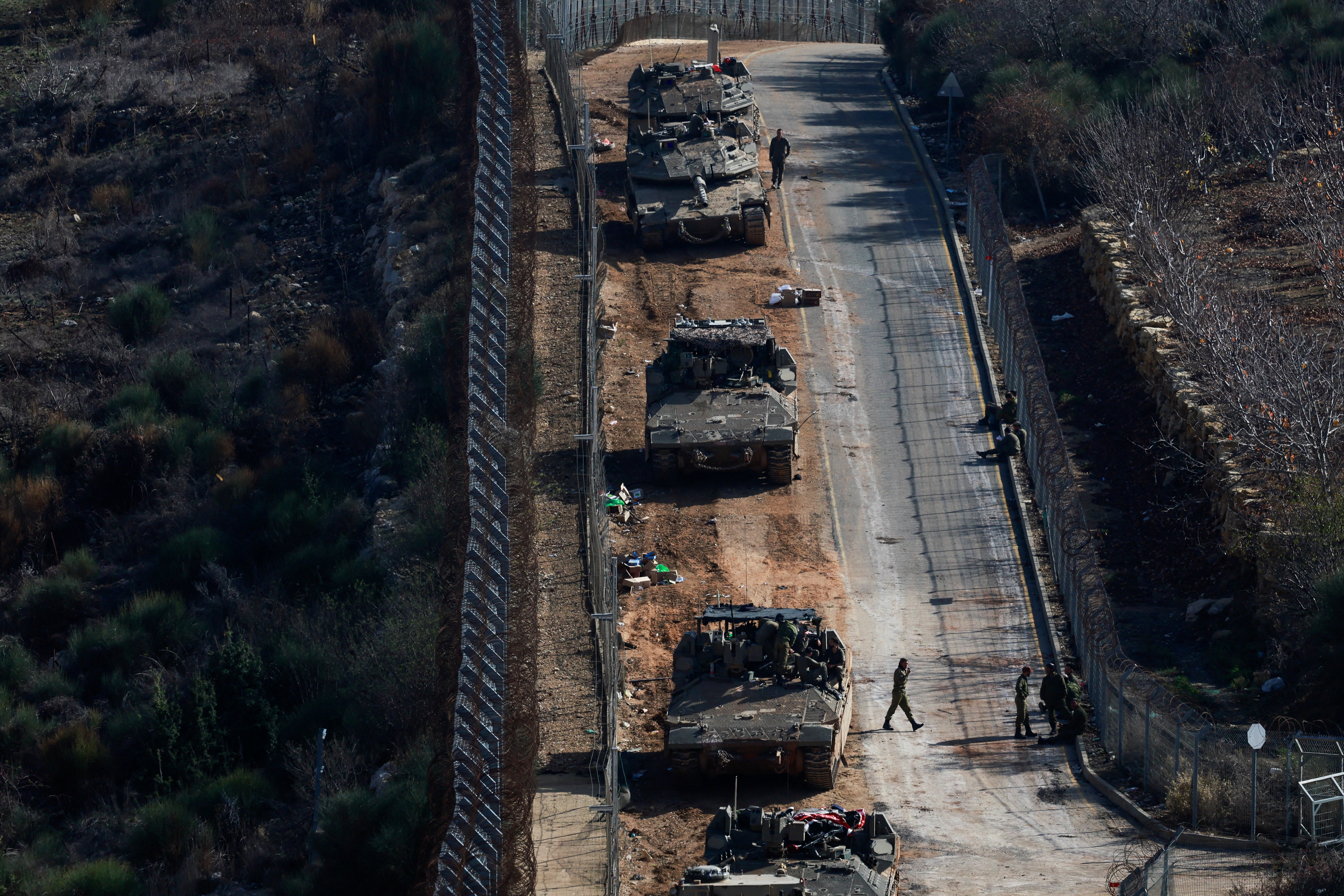 Israeli soldiers gather near the ceasefire line between Syria and the Israeli-occupied Golan Heights