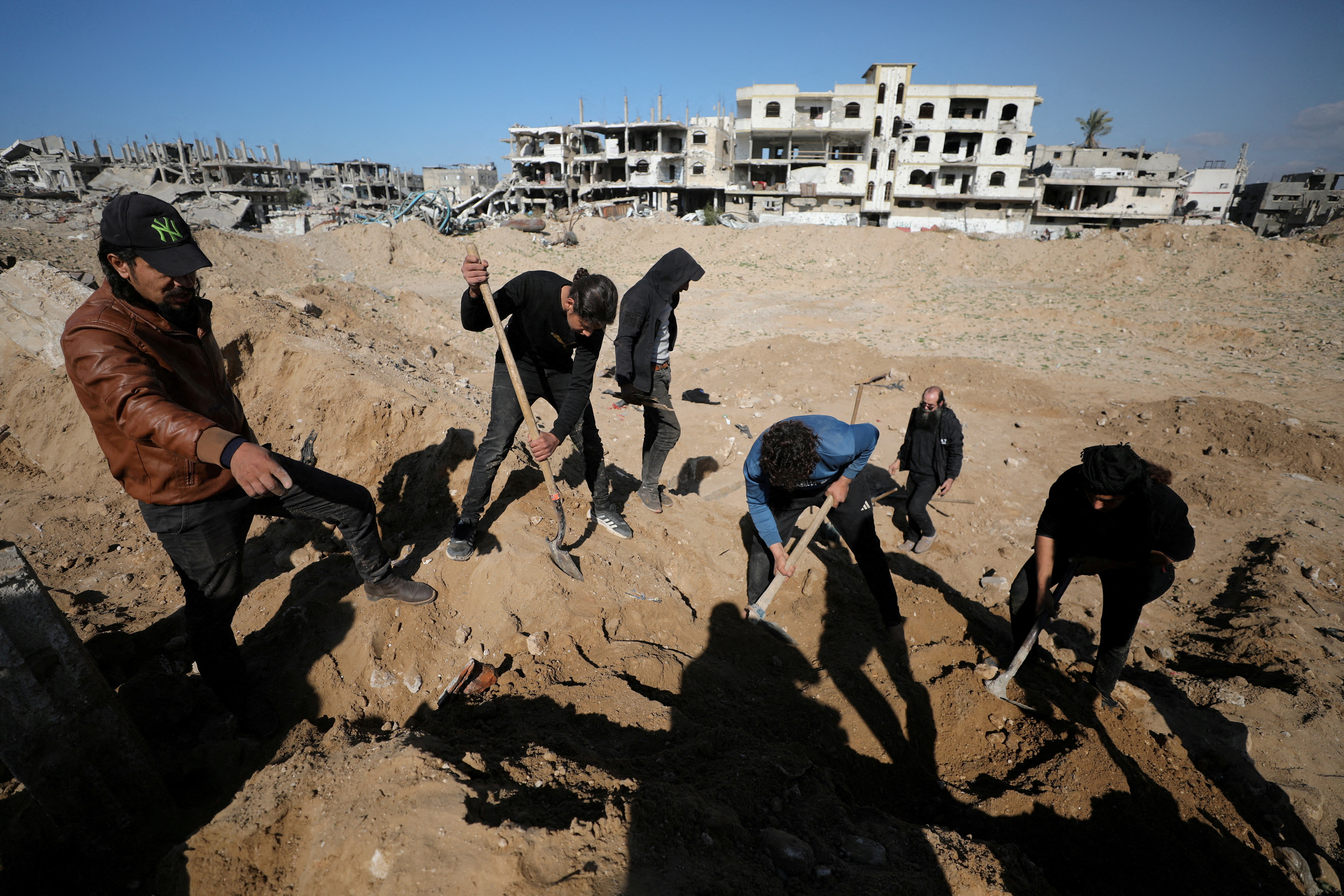 Palestinians search for bodies and graves of loved ones following a ceasefire, in Gaza City