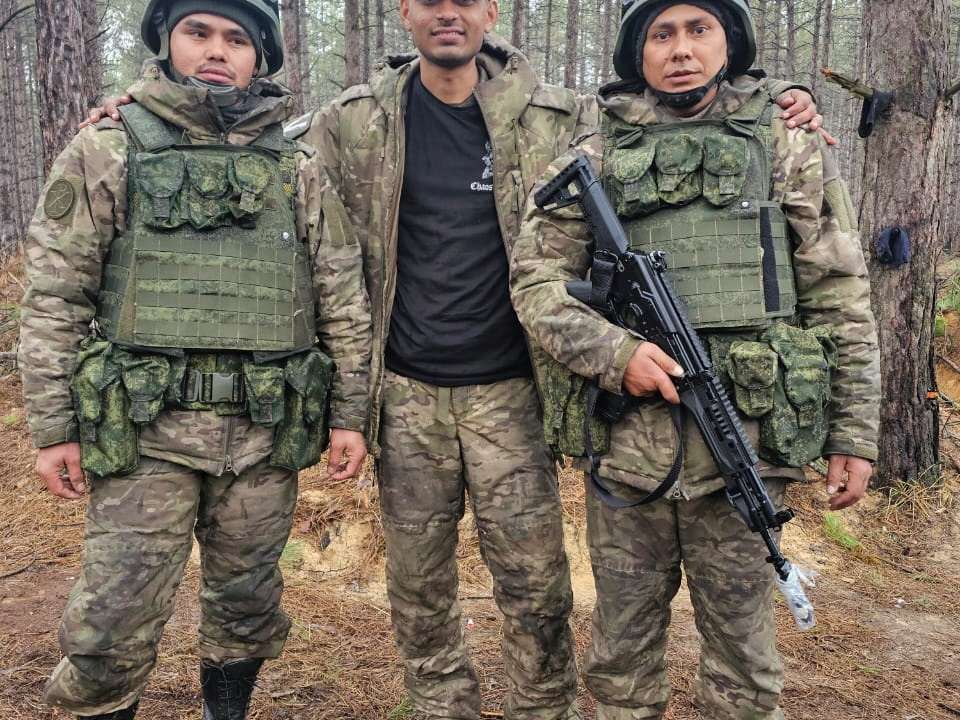 Hemil Mangukiya, middle, poses for a photograph with two other men in military uniform