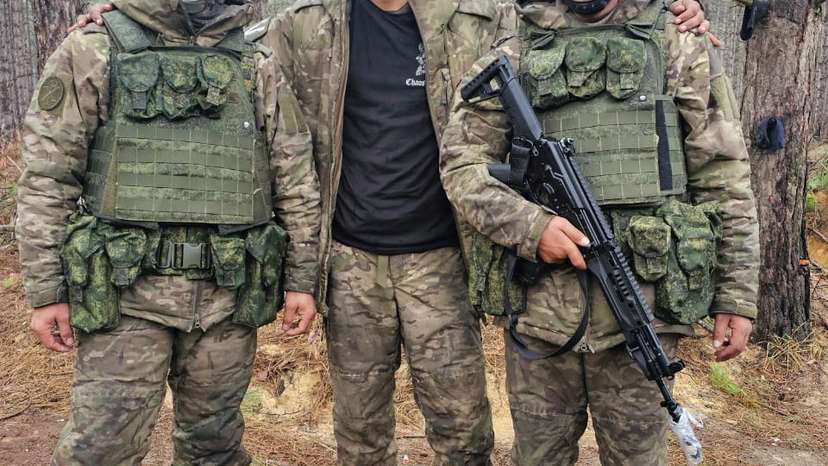 Hemil Mangukiya, middle, poses for a photograph with two other men in military uniform