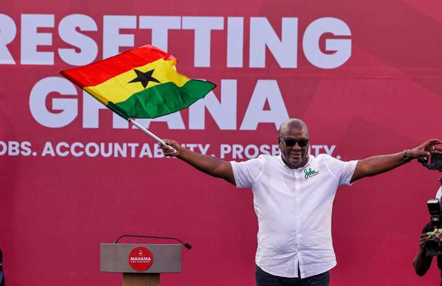 National Democratic Congress (NDC) presidential candidate and former Ghanaian President John Dramani Mahama holds a national flag as he waves to supporters during his final election campaign rally in Accra, Ghana December 5, 2024. REUTERS/Zohra Bensemra
