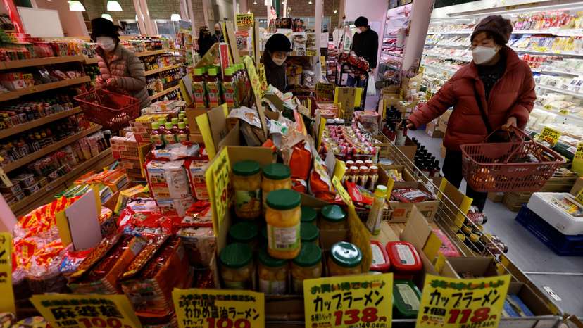 Shoppers check food items at a supermarket in Tokyo