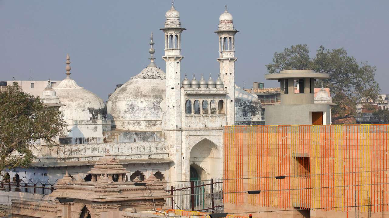 FILE PHOTO: A worker stands on a temple rooftop adjacent to the Gyanvapi Mosque