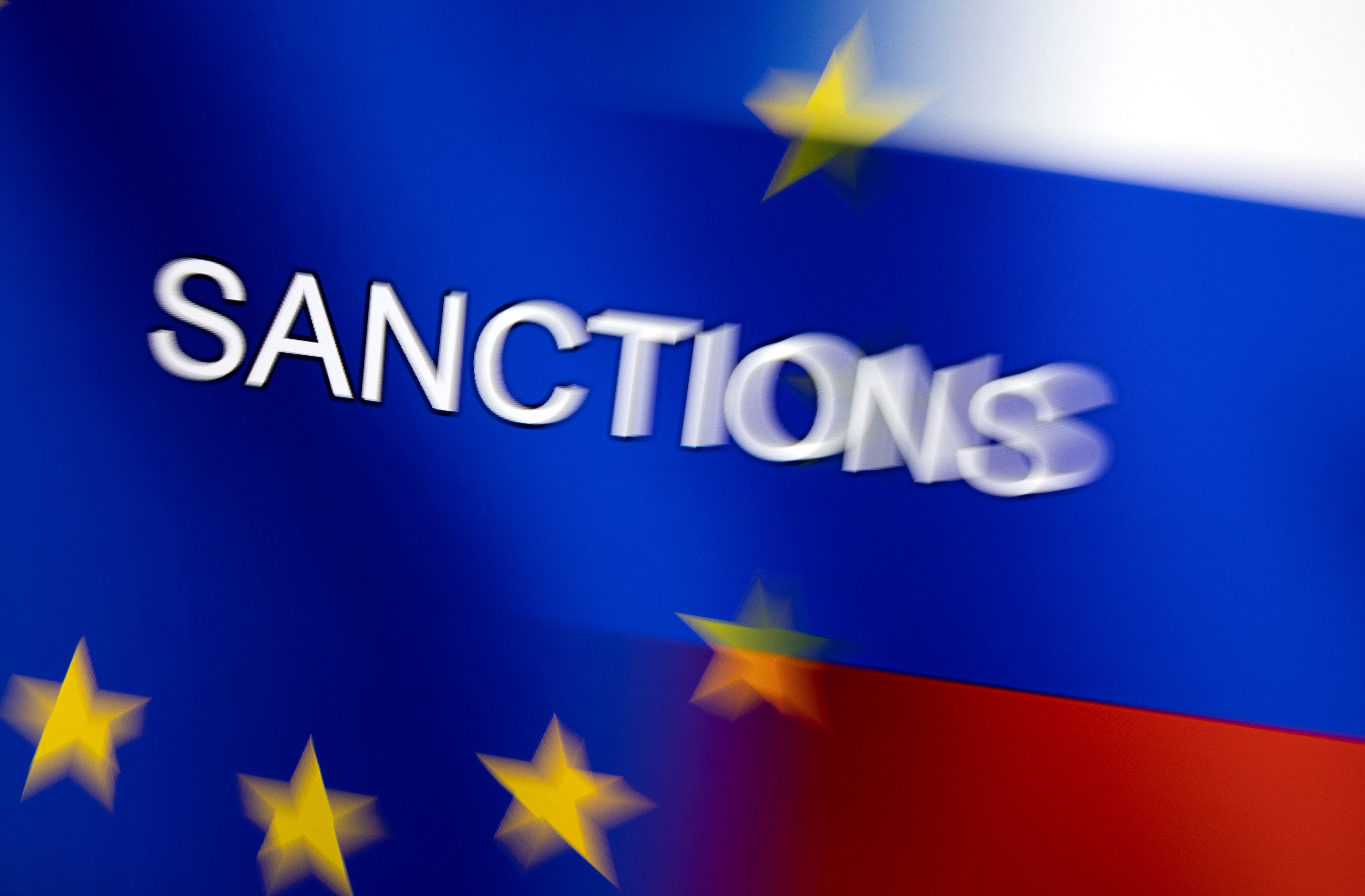 Illustration shows word "Sanctions" displayed on EU and Russian flags