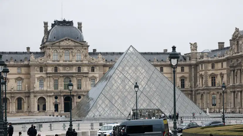 Police stand near the pyramid of the Louvre museum after reports of a robbery, in Paris