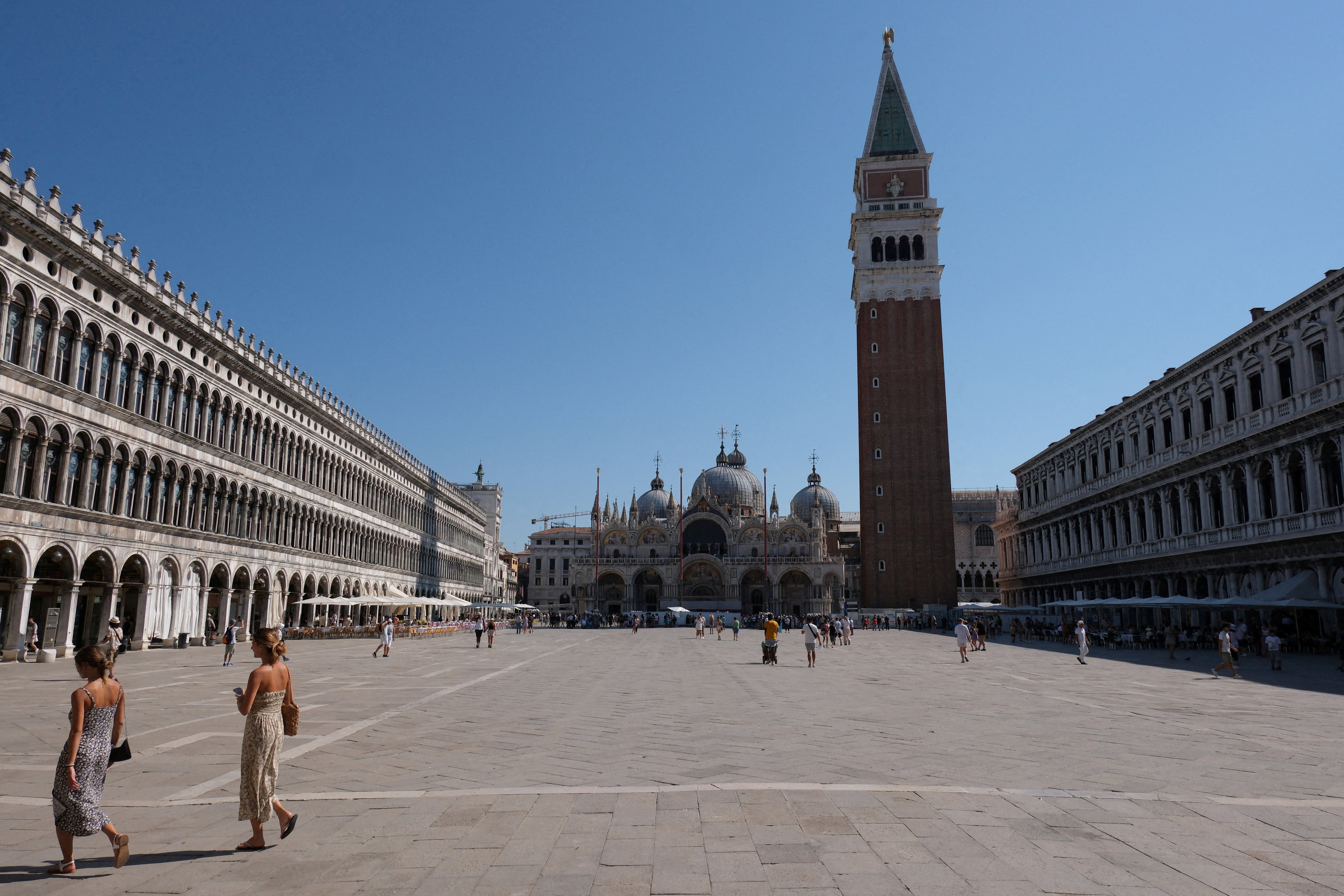 FILE PHOTO: Tourists walk during a new heatwave in Venice