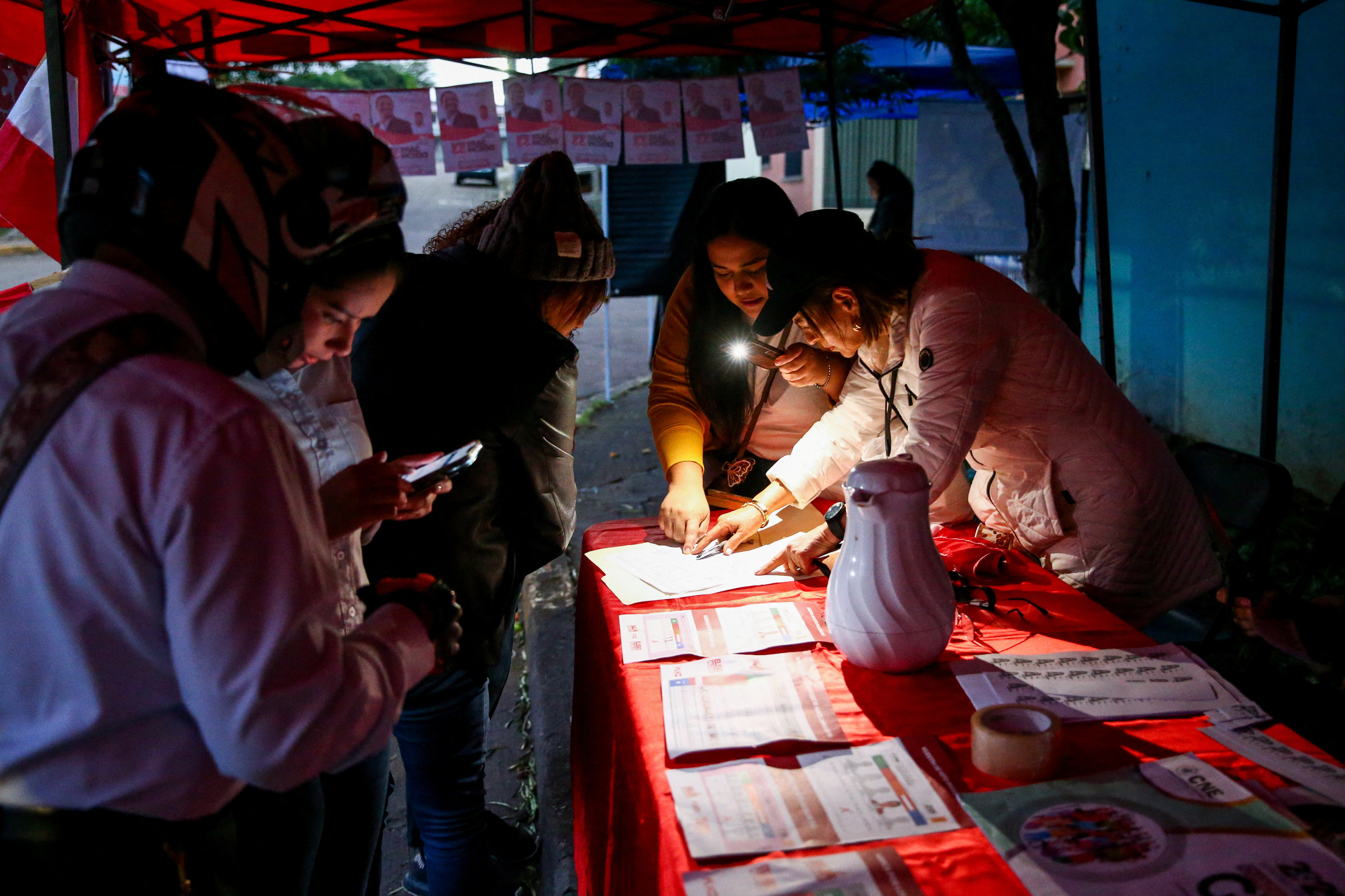People set up an information booth outside a polling station, on the day of the general election, in Tegucigalpa, Honduras, November 30, 2025. REUTERS/Jose Cabezas