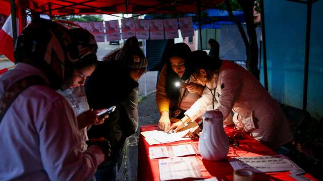People set up an information booth outside a polling station, on the day of the general election, in Tegucigalpa, Honduras, November 30, 2025. REUTERS/Jose Cabezas
