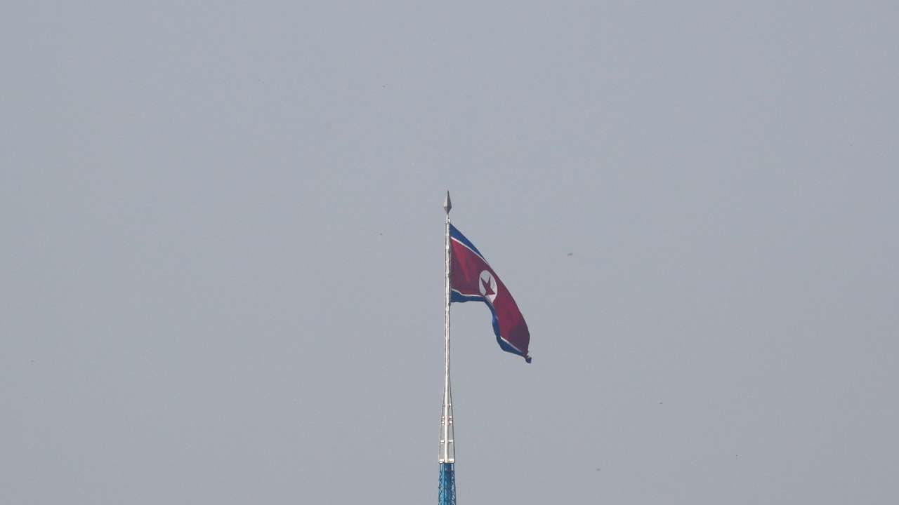 FILE PHOTO: A North Korean flag flutters on top of a tower at North Korea's propaganda village of Gijungdong, as seen from Paju
