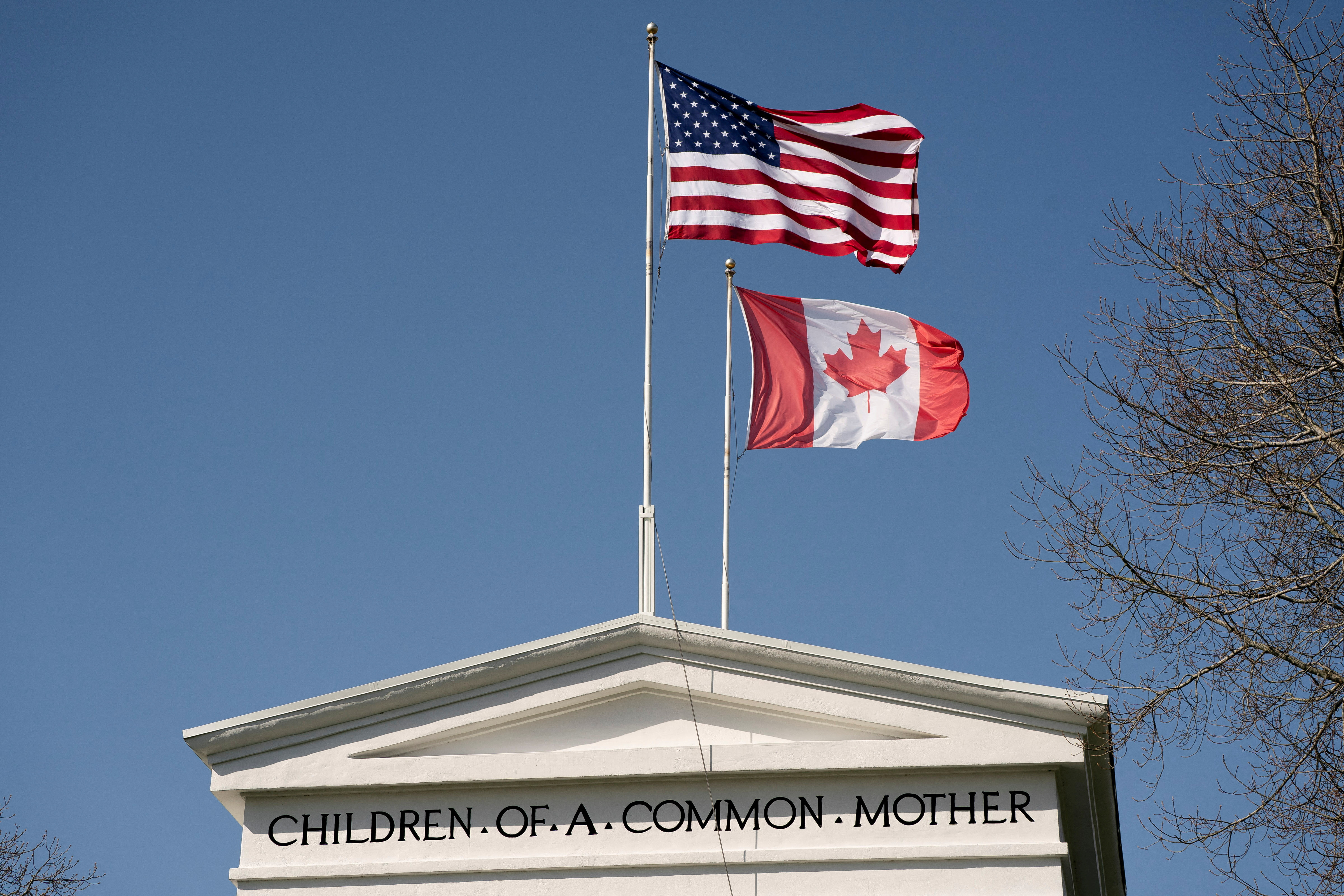 FILE PHOTO: Flags fly above the Peace Arch, on the day U.S. President Donald Trump announced new tariffs, at a Canada-U.S. border crossing known as the Peace Arch Border Crossing in Blaine