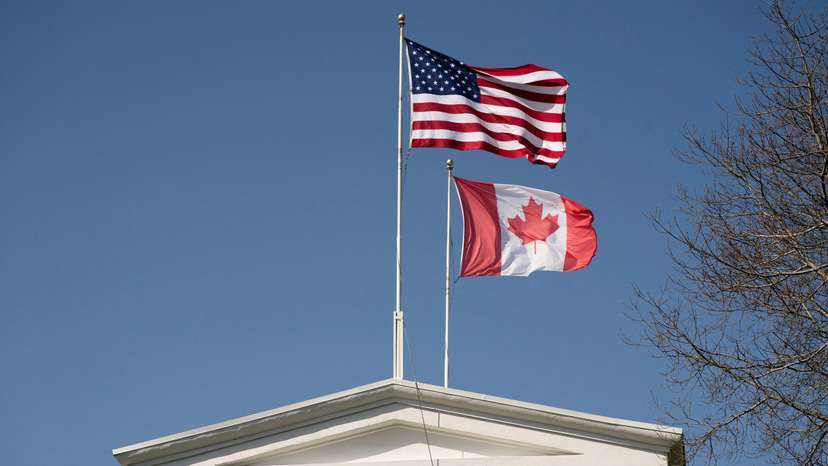FILE PHOTO: Flags fly above the Peace Arch, on the day U.S. President Donald Trump announced new tariffs, at a Canada-U.S. border crossing known as the Peace Arch Border Crossing in Blaine
