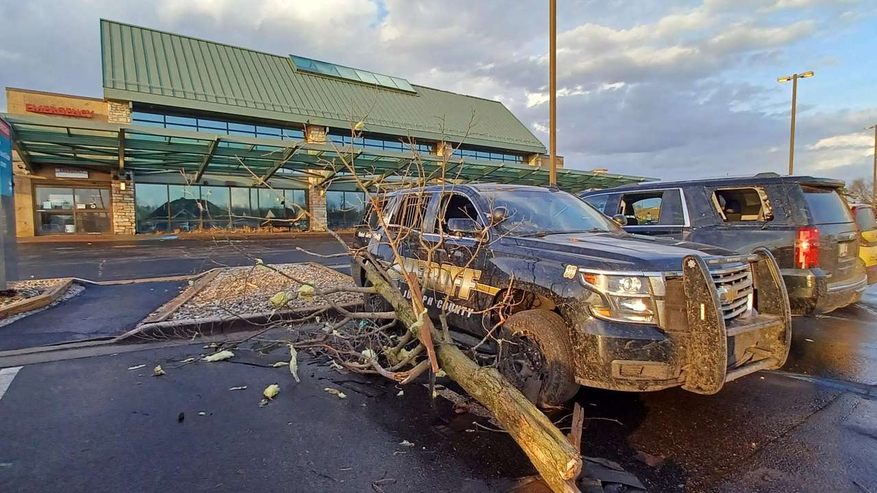 A fallen tree rests again a Sheriff's vehicle outside a hospital following storms and tornado warnings in Three Rivers