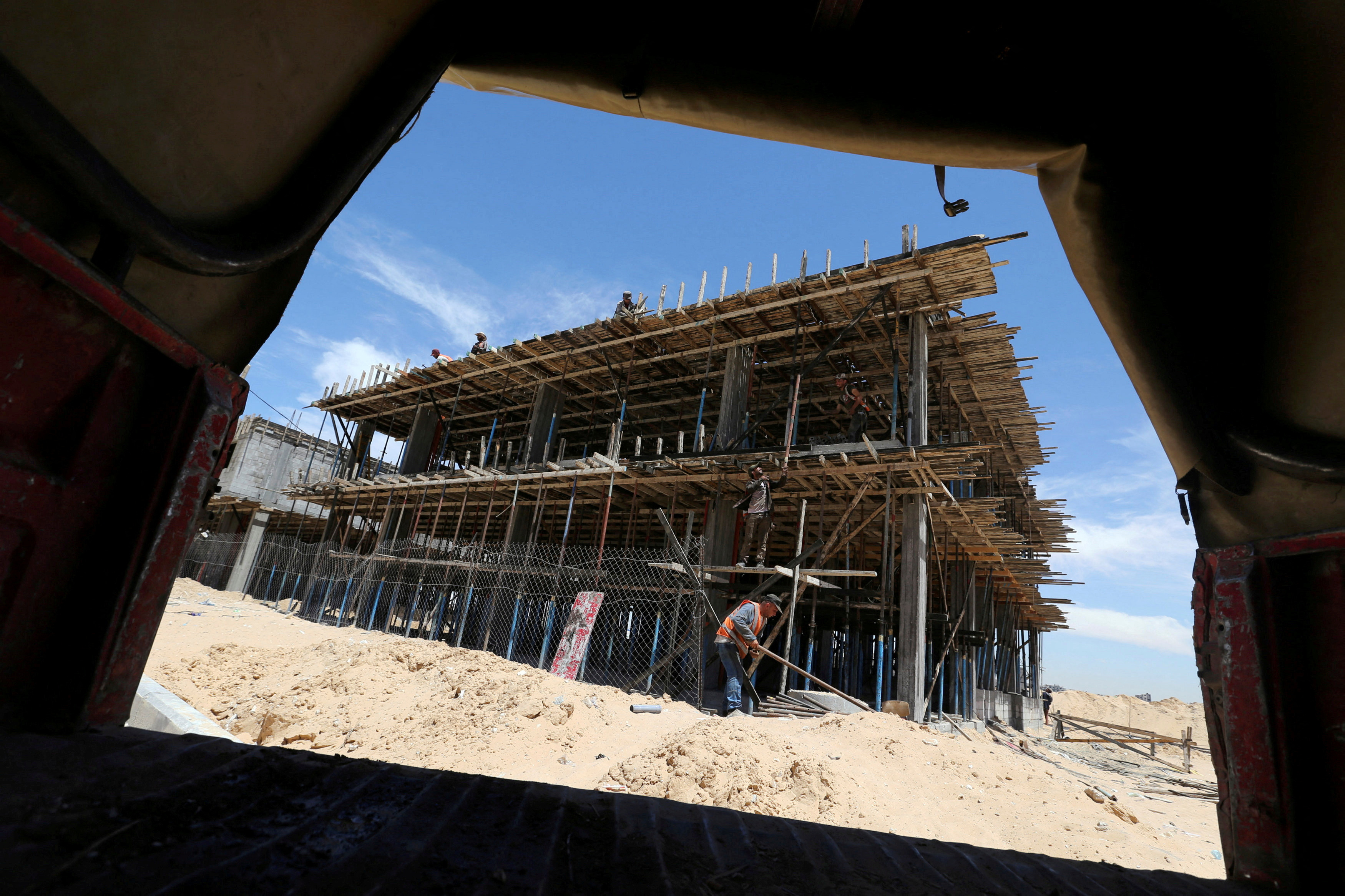 FILE PHOTO: Palestinian workers work on a Qatari-funded construction project in the southern Gaza Strip