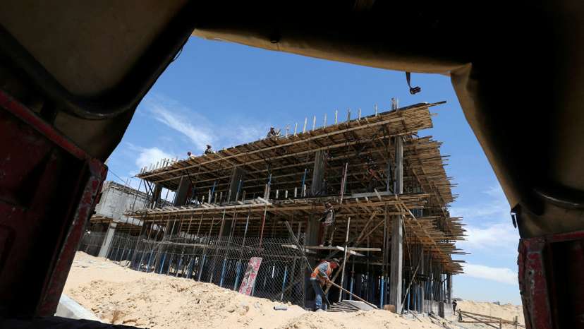 FILE PHOTO: Palestinian workers work on a Qatari-funded construction project in the southern Gaza Strip