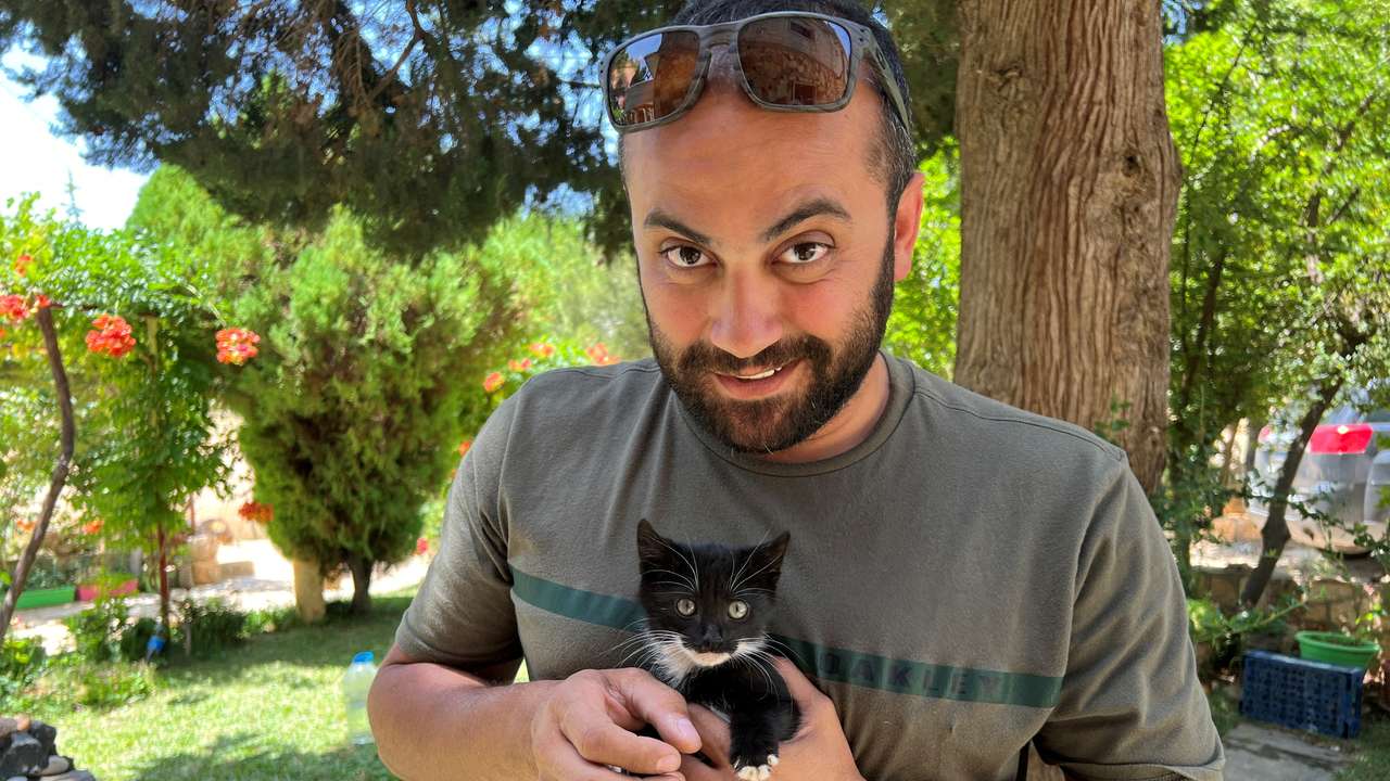 Reuters visuals journalist Issam Abdallah holds a kitten while posing for a picture in Saaideh, Lebanon