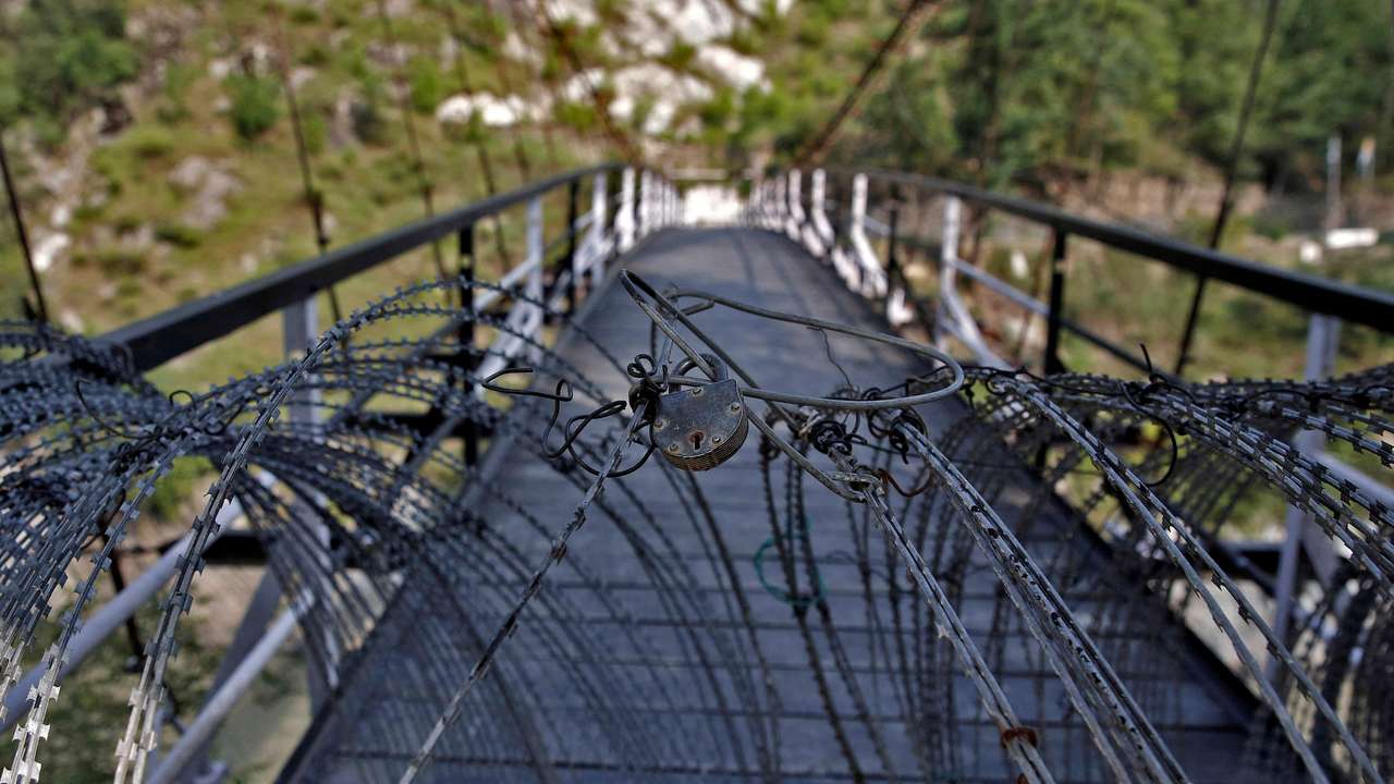 FILE PHOTO: A view shows a padlock on concertina wires on a footbridge connecting Indian administered Kashmir and Pakistan administered Kashmir in Teetwal
