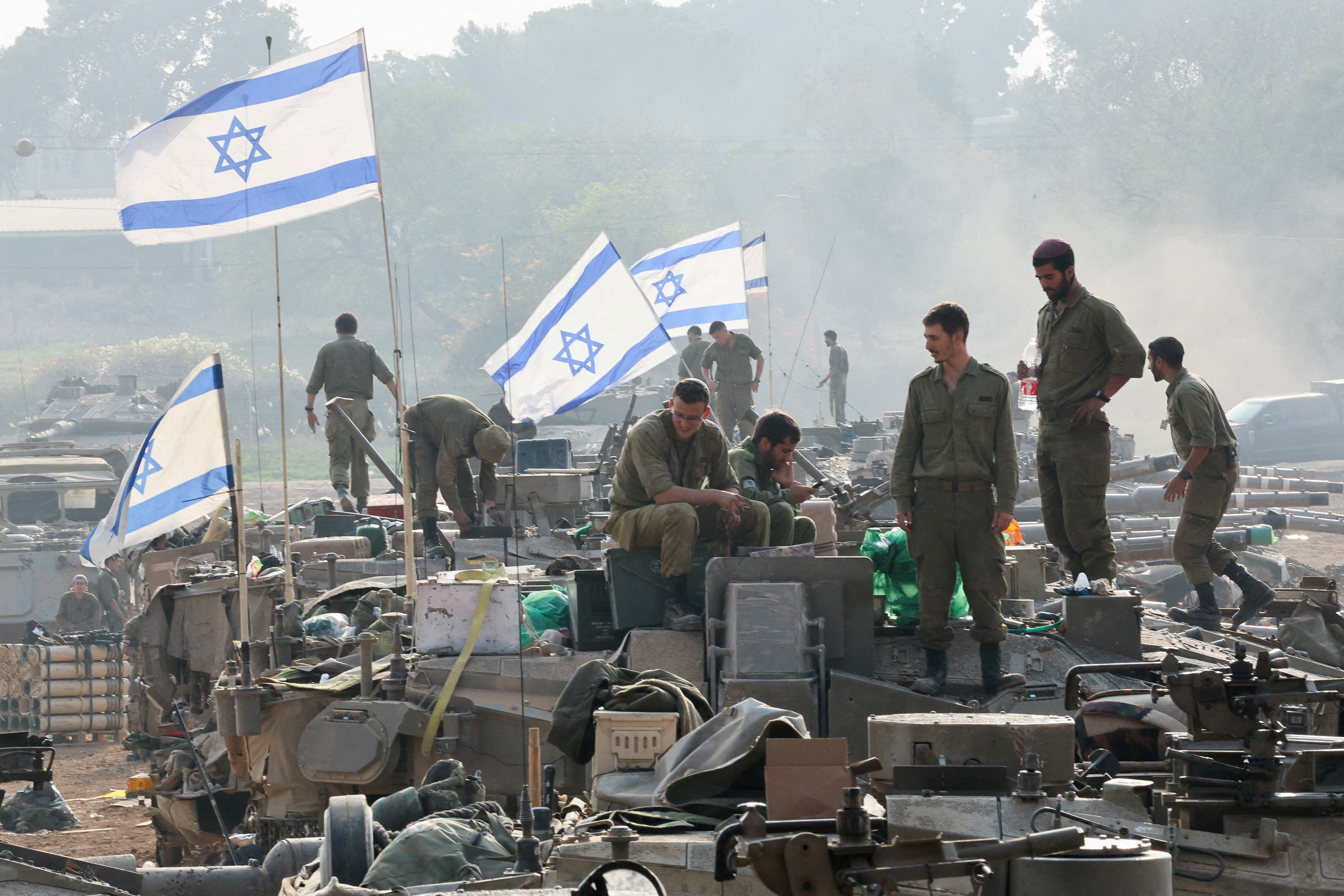 FILE PHOTO: Israeli soldiers stand on tanks, near the Israel-Gaza border