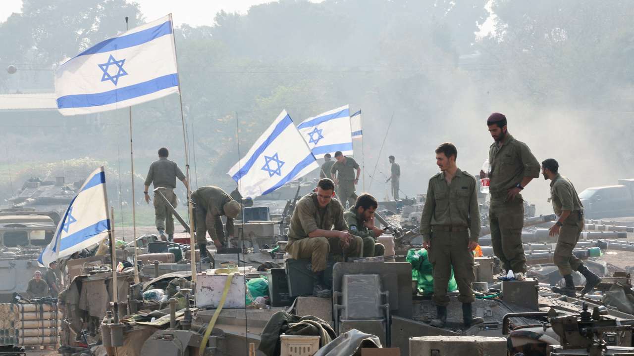 FILE PHOTO: Israeli soldiers stand on tanks, near the Israel-Gaza border