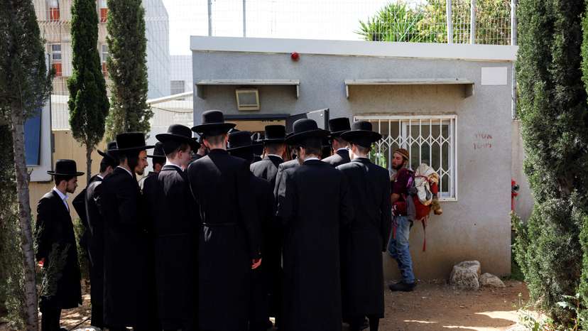 FILE PHOTO: Ultra-Orthodox Jews line up at an Israeli draft office to process their exemptions from mandatory military service at a recruitment base in Kiryat Ono