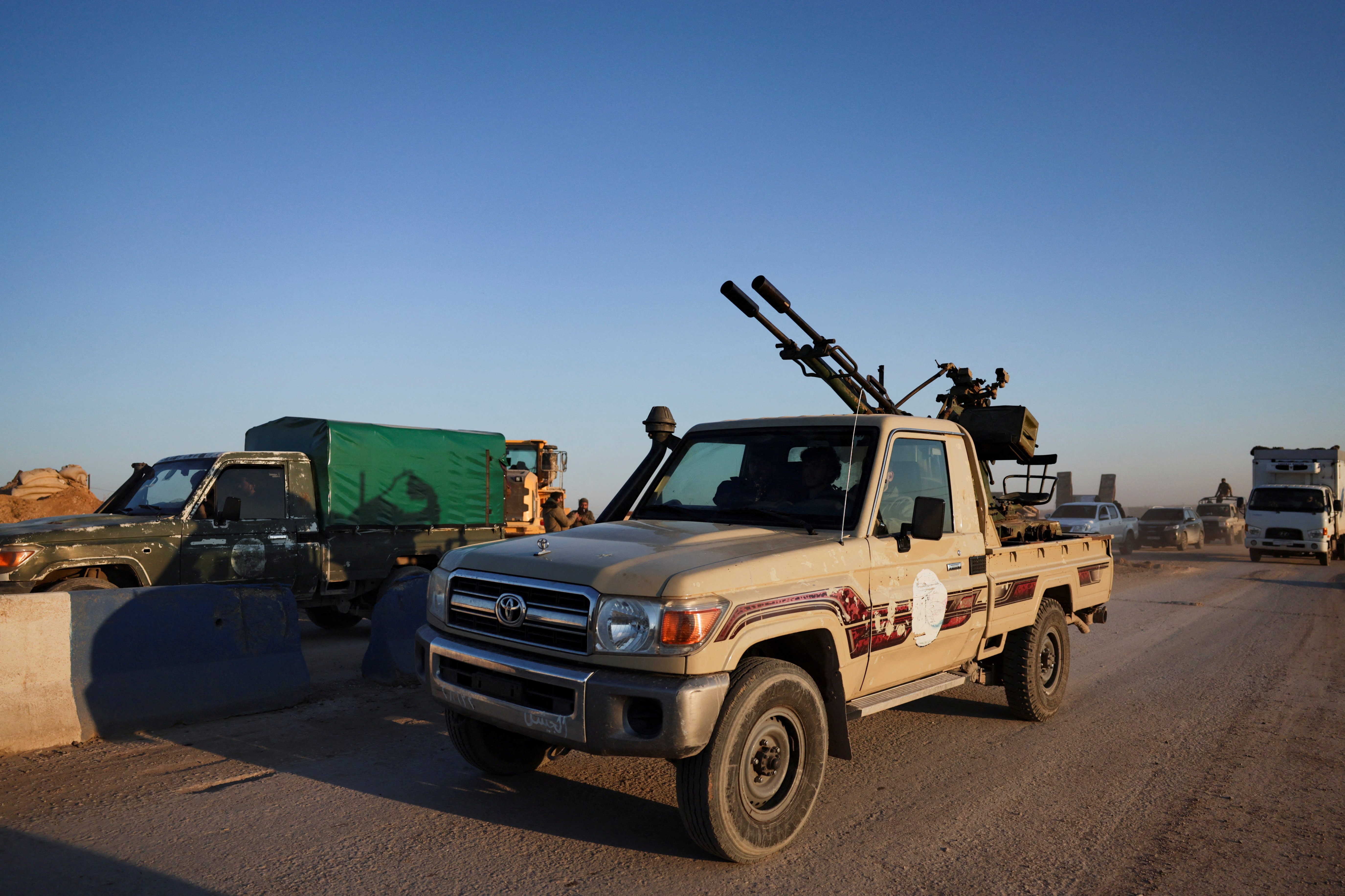 Members of the Syrian army ride a vehicle en route to Al-Hasakah, following the withdrawal of the Syrian Democratic Forces
