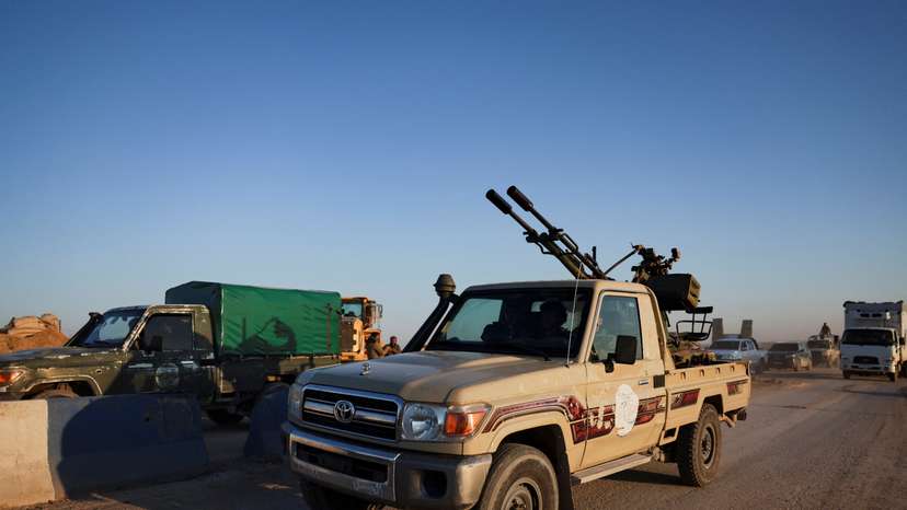 Members of the Syrian army ride a vehicle en route to Al-Hasakah, following the withdrawal of the Syrian Democratic Forces
