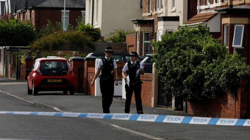Police officers walk near the scene in Hart street where a man was arrested after people were stabbed in Southport