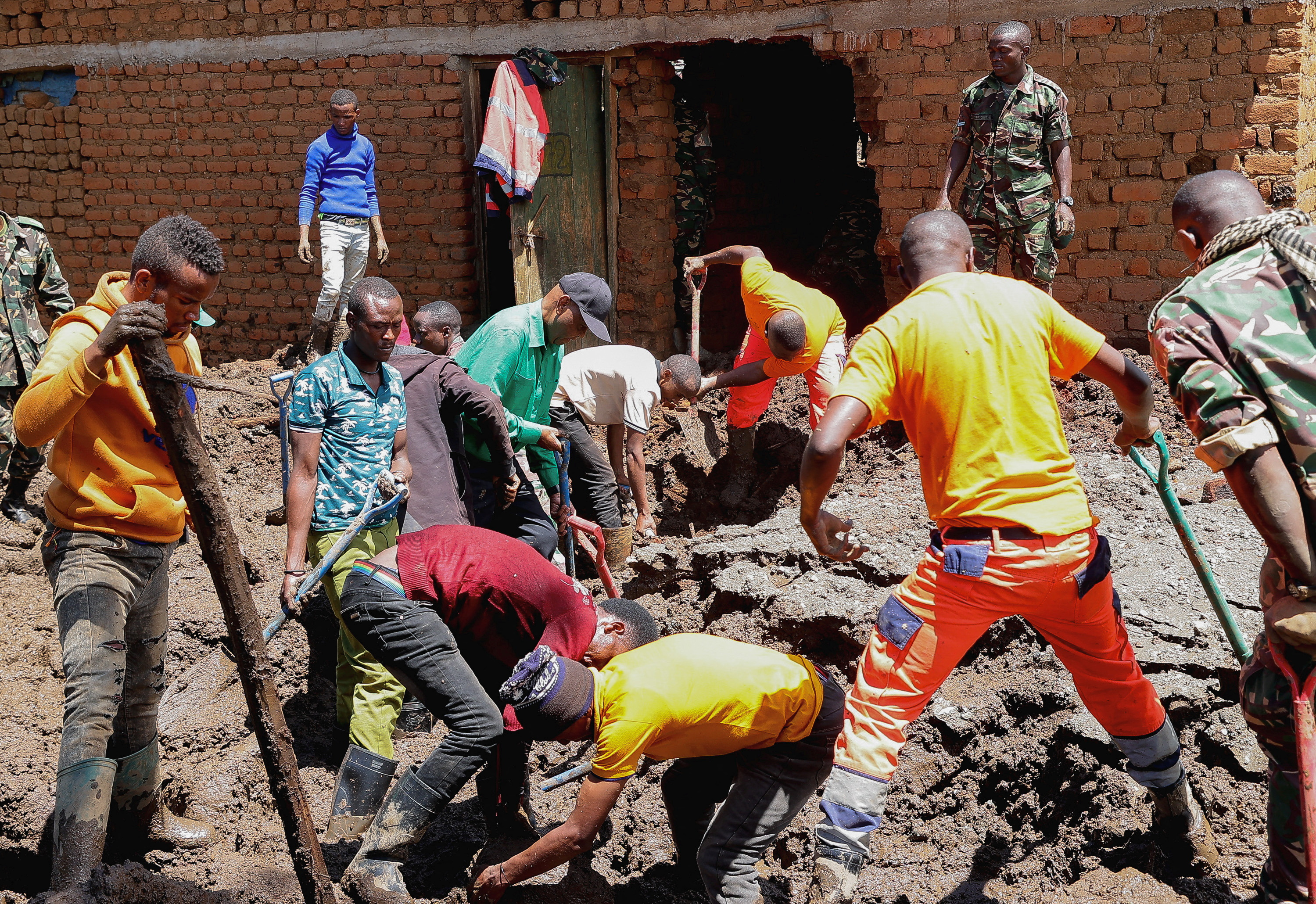 Members of the Tanzania Defense Forces and rescuers search for the bodies of people killed following flash floods and landslides near the slopes of Mount Hanang in the Manyara