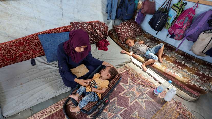 The mother of Palestinian boy Abdul Rahman Abu Al-Jidyan, who is the first person to contract polio in Gaza in 25 years, looks after him in their tent, in Deir Al-Balah, in the central Gaza Strip