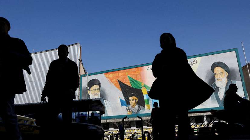 FILE PHOTO: People walk near a mural featuring images of Iran's Supreme Leader Ayatollah Ali Khamenei and leader of Iran's 1979 Islamic Revolution Ayatollah Ruhollah Khomeini, on a street in Tehran