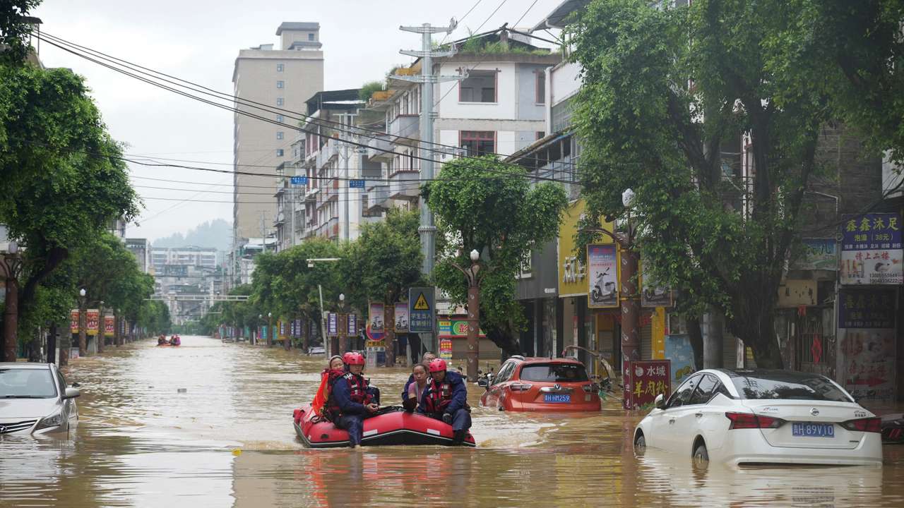 Rescue workers evacuate flood-affected residents with a boat in Rongjiang county, Guizhou