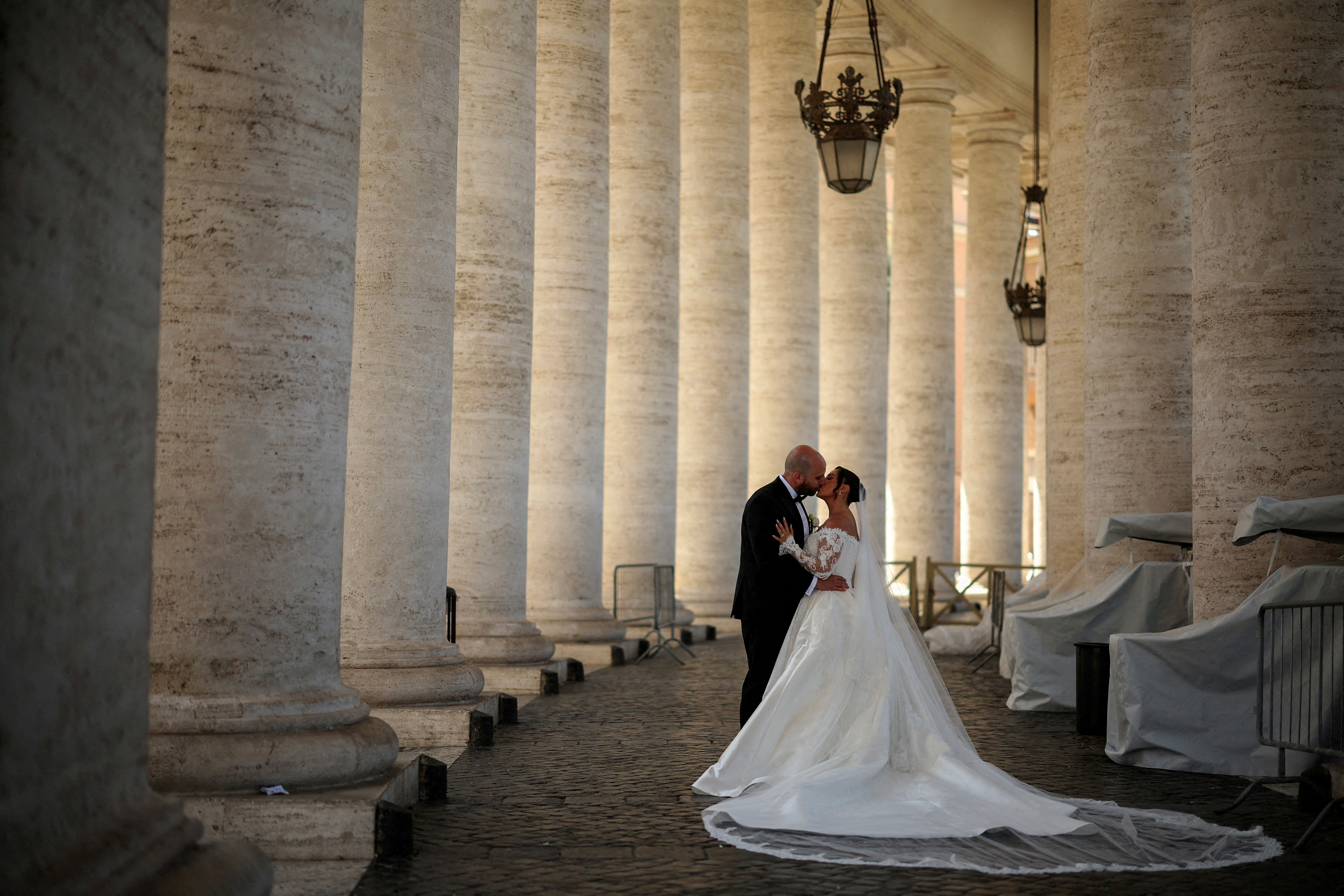 FILE PHOTO: A couple kiss during their wedding photo session under the Vatican colonnade in the Vatican