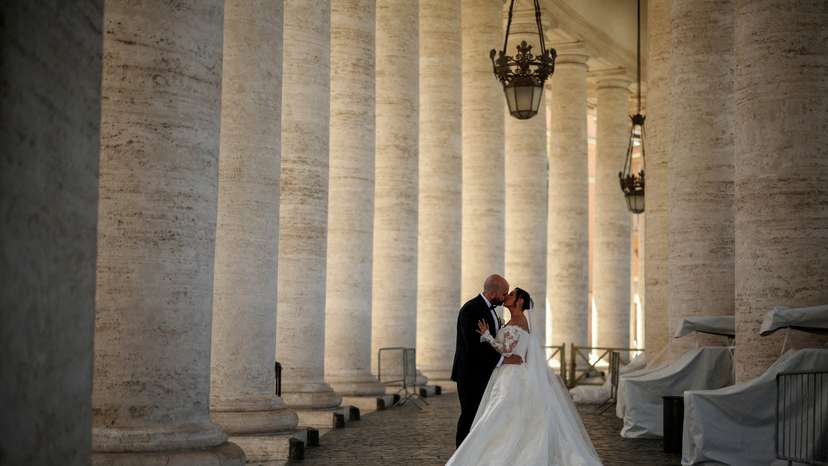 FILE PHOTO: A couple kiss during their wedding photo session under the Vatican colonnade in the Vatican