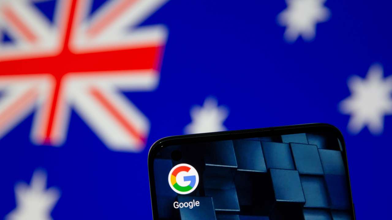 Smartphone with google app icon is seen in front of the displayed Australian flag in this illustration taken