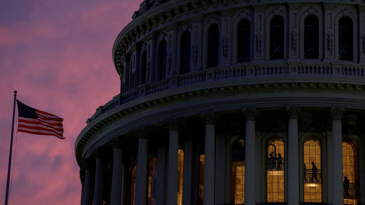 FILE PHOTO: People walk inside the upper floors of the rotunda of the U.S. Capitol building at sunset in Washington