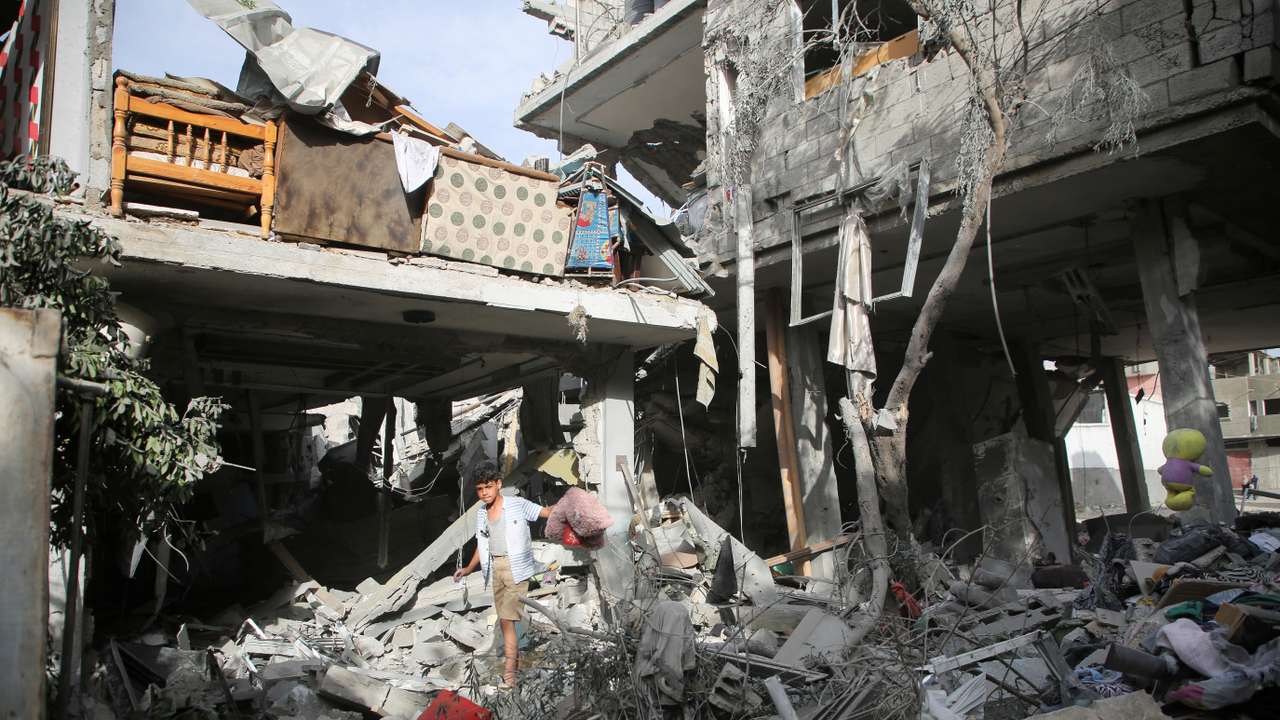 Palestinians inspect the site of an Israeli strike on a house in Rafah
